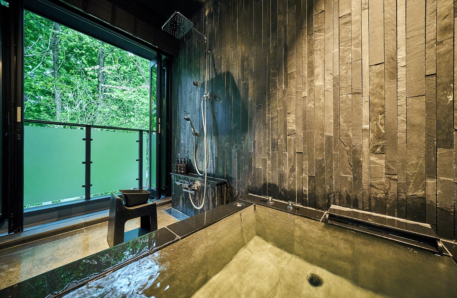 全客室に備え付けられた天然温泉の石造りの半露天風呂